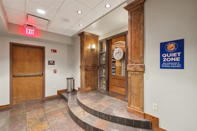 tiled entrance foyer featuring a drop ceiling