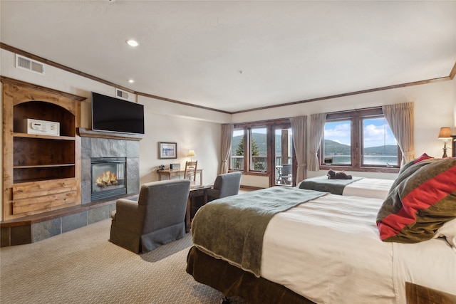 carpeted bedroom with a tiled fireplace and ornamental molding