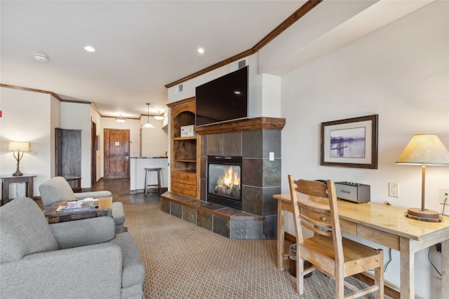 living room featuring crown molding, carpet floors, and a tile fireplace