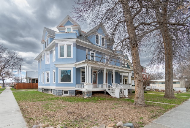 victorian home with covered porch and a front yard