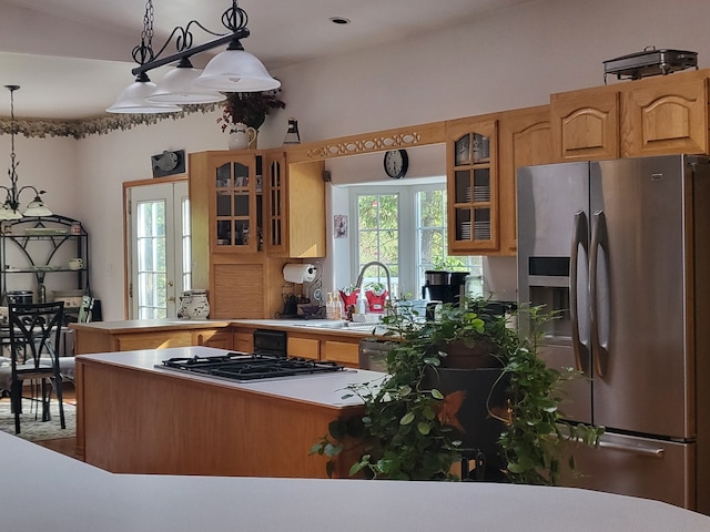 kitchen featuring stainless steel appliances, hardwood / wood-style floors, sink, kitchen peninsula, and pendant lighting