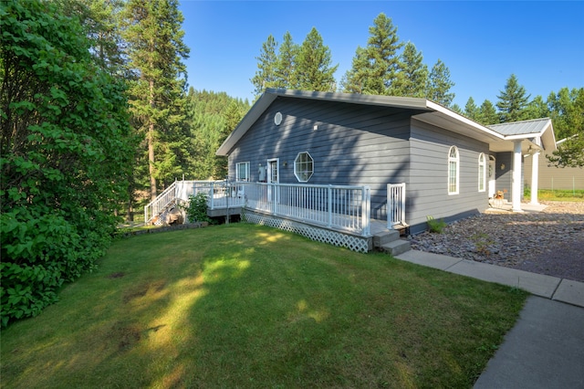 view of home's exterior featuring a deck and a yard