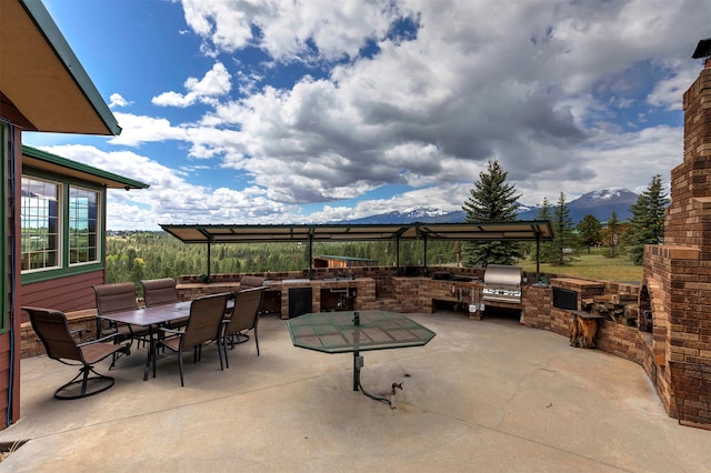 view of patio with a mountain view and an outdoor kitchen