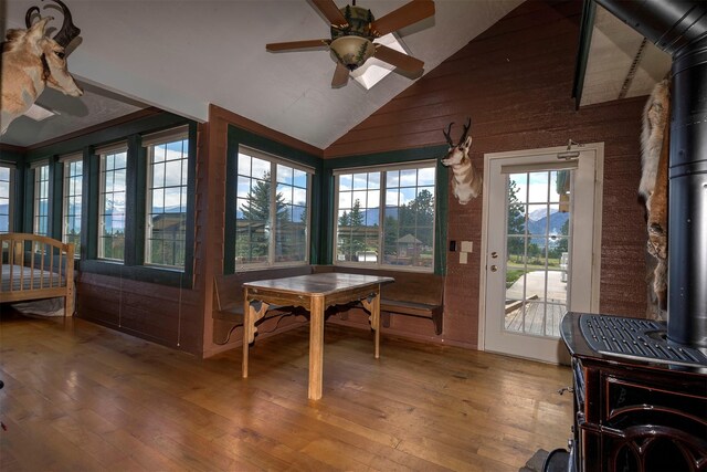 5282 Otto Way, Florence, MT 59833 - sunroom / solarium featuring a wood stove, wood-type flooring, wooden walls, and high vaulted ceiling