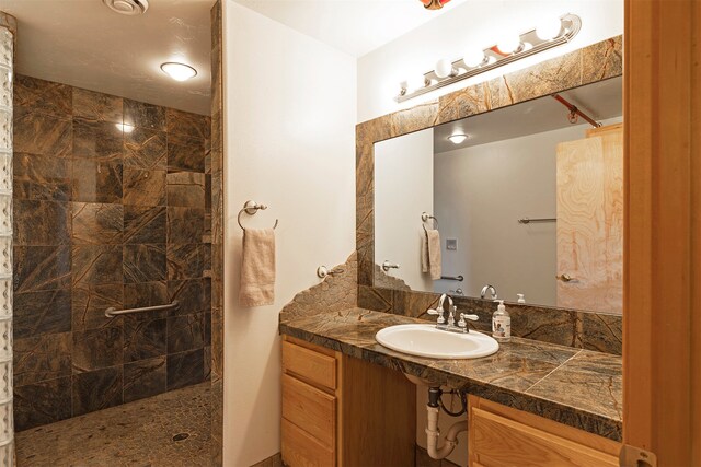 bathroom featuring a tile shower and vanity