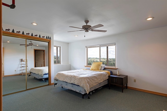 carpeted bedroom featuring ceiling fan, multiple windows, and a closet