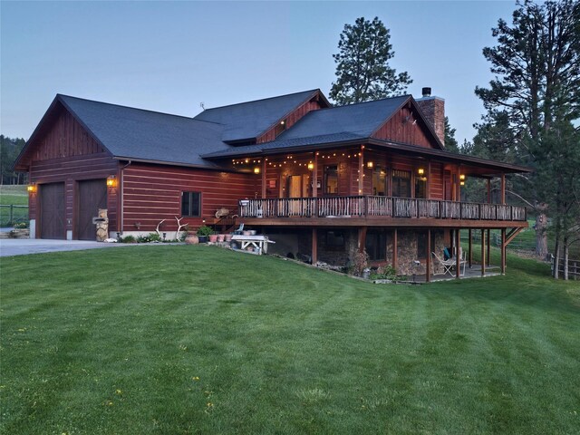 856 Weber Butte Trl, Corvallis, MT 59828 - rear view of house with a chimney, a yard, a garage, a deck, and asphalt driveway