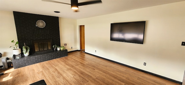 living room with ceiling fan, light hardwood / wood-style flooring, and a fireplace