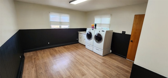 washroom featuring light hardwood / wood-style floors, washer and dryer, and cabinets