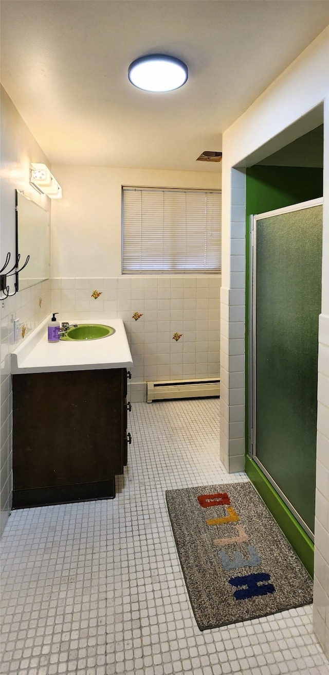 bathroom featuring tile walls, vanity, and a shower with shower door