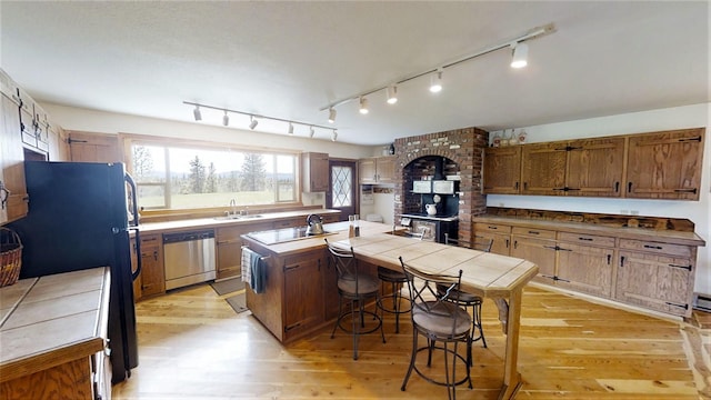 3653 Sophie Lake Rd, Eureka, MT 59917 - kitchen with stainless steel dishwasher, a center island, light wood-style floors, and freestanding refrigerator