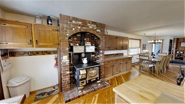 3653 Sophie Lake Rd, Eureka, MT 59917 - kitchen with a wood stove, a chandelier, light wood-style flooring, and hanging light fixtures