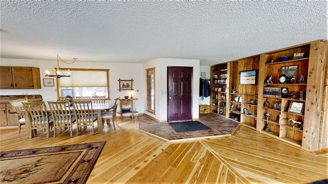 3653 Sophie Lake Rd, Eureka, MT 59917 - dining room with light wood finished floors, a chandelier, and a textured ceiling