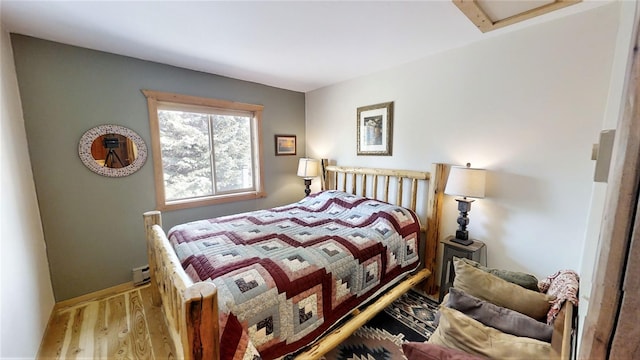 3653 Sophie Lake Rd, Eureka, MT 59917 - bedroom with wood finished floors, baseboard heating, and attic access