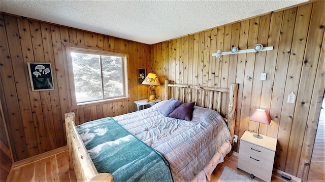 3653 Sophie Lake Rd, Eureka, MT 59917 - bedroom with hardwood / wood-style flooring, a textured ceiling, and wood walls