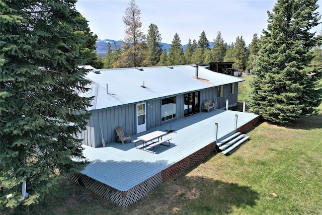 3653 Sophie Lake Rd, Eureka, MT 59917 - rear view of property featuring a lawn, a deck with mountain view, a metal roof, and board and batten siding