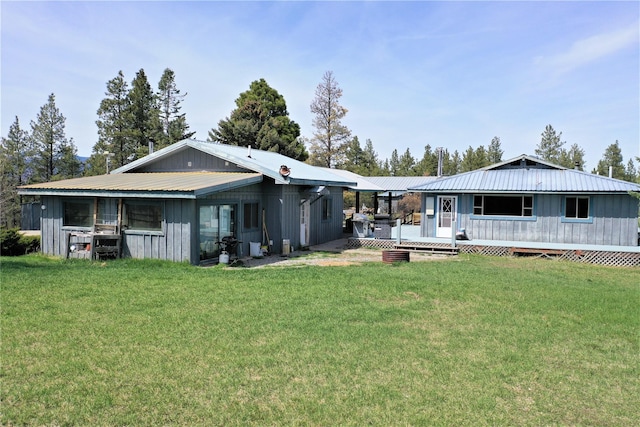 3653 Sophie Lake Rd, Eureka, MT 59917 - rear view of property featuring a wooden deck, a metal roof, a lawn, and board and batten siding