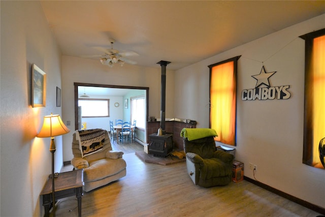3653 Sophie Lake Rd, Eureka, MT 59917 - living area featuring a wood stove, wood finished floors, and a ceiling fan