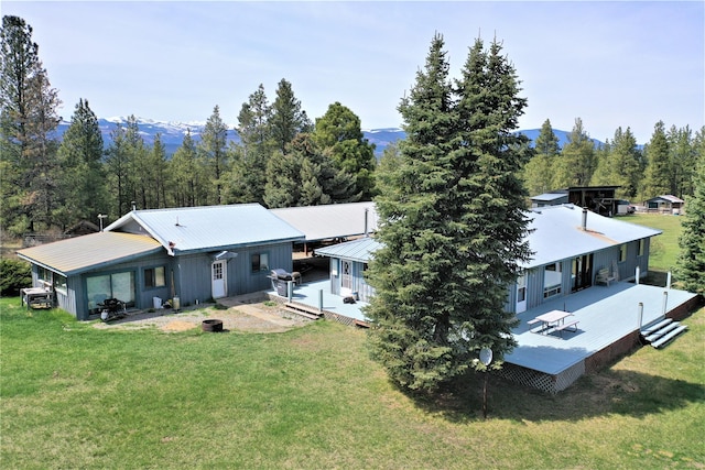 3653 Sophie Lake Rd, Eureka, MT 59917 - rear view of property with a deck with mountain view, a yard, a metal roof, and a view of trees