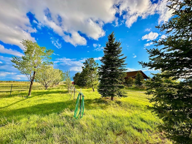 view of home's community featuring fence and a rural view