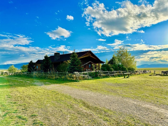 view of front facade featuring fence, a rural view, and a front yard