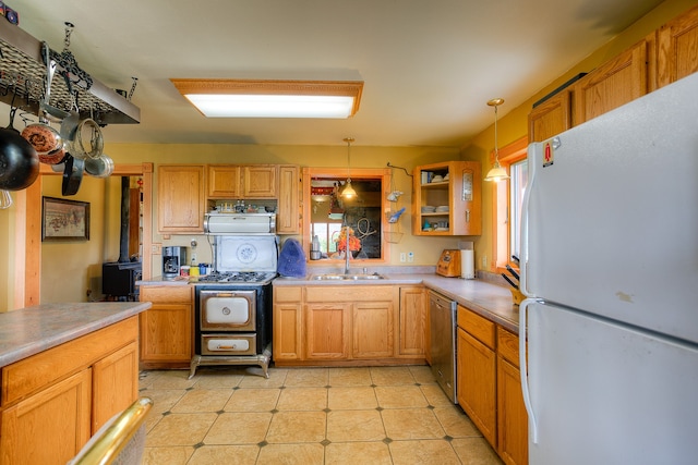 kitchen with stainless steel appliances, sink, light tile floors, and pendant lighting