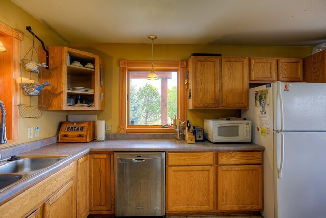 kitchen featuring white appliances, brown cabinets, and hanging light fixtures