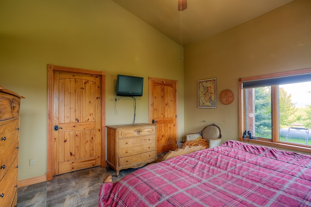 tiled bedroom featuring high vaulted ceiling and ceiling fan