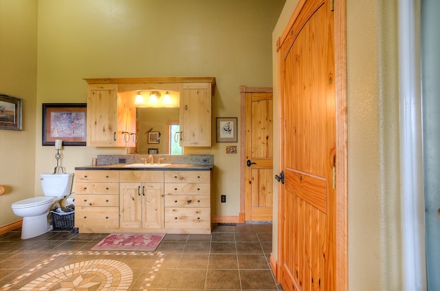 bathroom with vanity, toilet, and tile floors