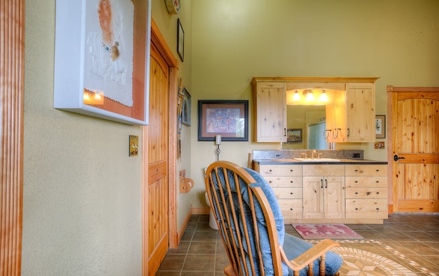 kitchen featuring light brown cabinets, dark tile flooring, and sink