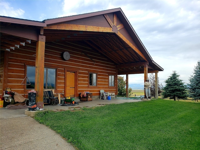 rear view of property featuring a lawn