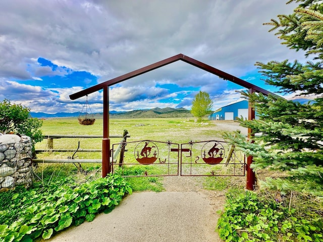 exterior space with a mountain view, fence, and a rural view