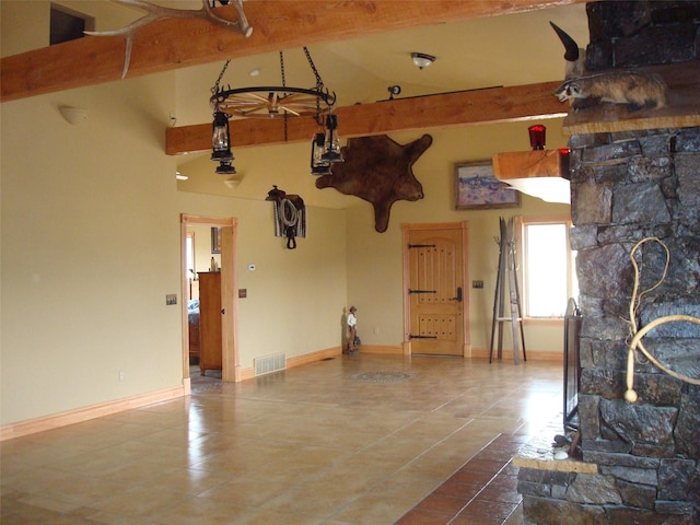 interior space with visible vents, tile patterned floors, baseboards, and vaulted ceiling with beams