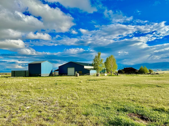 view of yard with a rural view and an outdoor structure