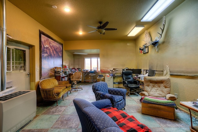 interior space with heating unit, a textured ceiling, and ceiling fan