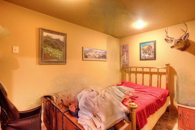 bedroom featuring a textured wall and a textured ceiling