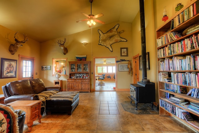 living room with high vaulted ceiling, tile flooring, and a wood stove