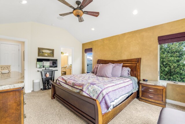 bedroom with ensuite bath, ceiling fan, vaulted ceiling, and light carpet