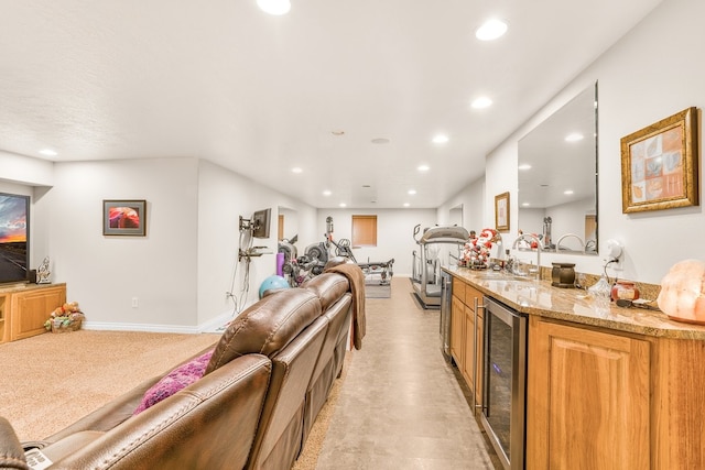 kitchen with beverage cooler, light carpet, sink, and light stone countertops