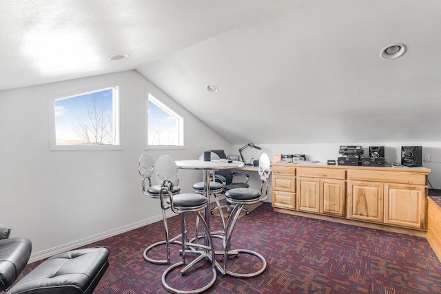 interior space featuring dark carpet and lofted ceiling