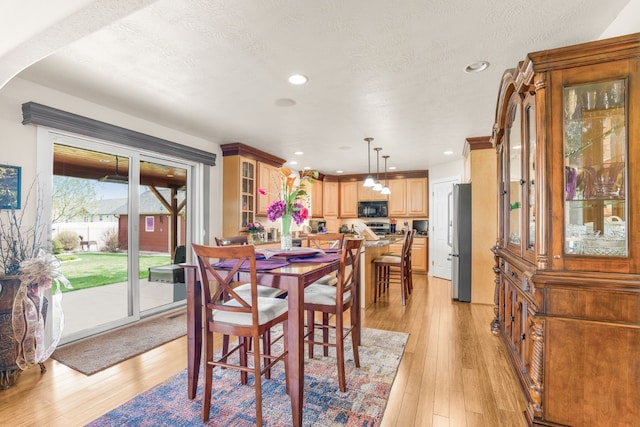 dining area featuring a textured ceiling and light wood-type flooring