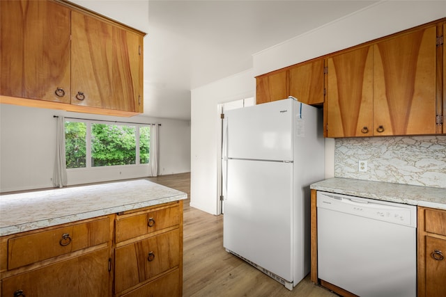 kitchen with light hardwood / wood-style flooring, white appliances, and tasteful backsplash