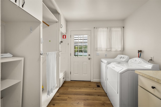 washroom with hardwood / wood-style floors, washer hookup, and washing machine and dryer