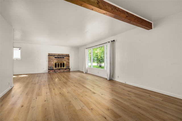 unfurnished living room with beamed ceiling, light hardwood / wood-style flooring, and a fireplace