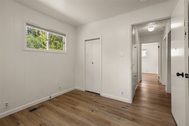 unfurnished bedroom with a closet and dark hardwood / wood-style flooring