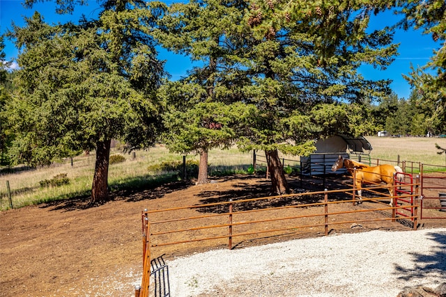 view of yard with a rural view, an exterior structure, and an outbuilding