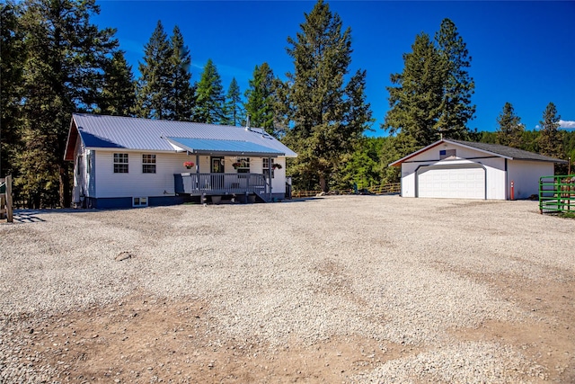 1200 Lost Creek Dr, Kalispell, MT 59901 - view of front facade featuring a garage, an outbuilding, a wooden deck, and a metal roof