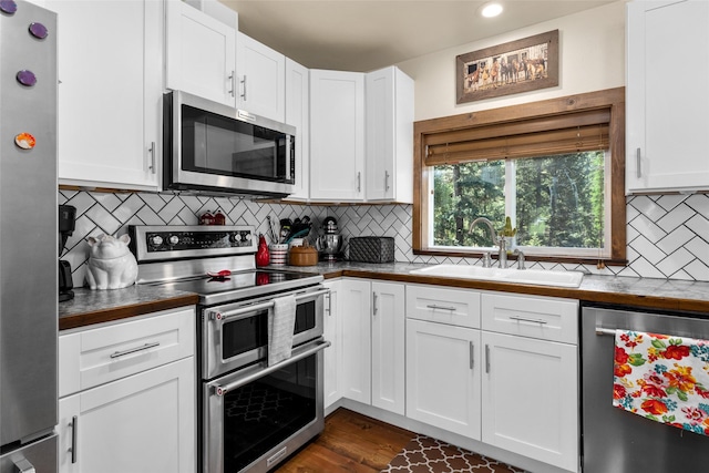 1200 Lost Creek Dr, Kalispell, MT 59901 - kitchen featuring stainless steel appliances, white cabinets, tasteful backsplash, recessed lighting, and dark countertops