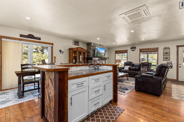 kitchen with light wood-type flooring, white cabinetry, and a wealth of natural light