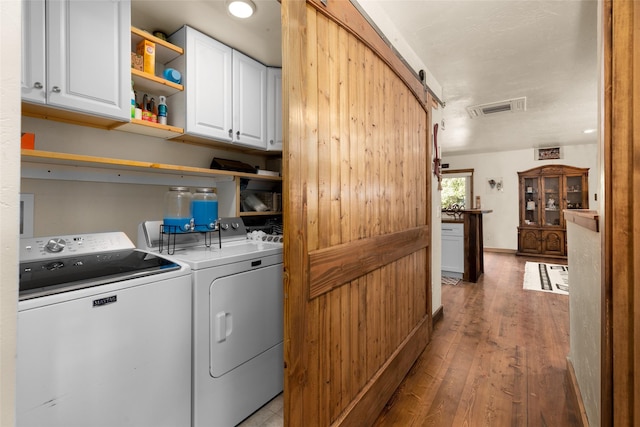 1200 Lost Creek Dr, Kalispell, MT 59901 - washroom featuring cabinet space, washer and clothes dryer, and light wood-type flooring